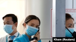 Punëtorët e aeroportit në Vietnam me maska mbrojtëse.