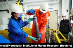 Louise Kiel Jensen (left) and Hans-Christian Teien take samples from the Komsomolets on July 10 to be analyzed for radioactive substances.