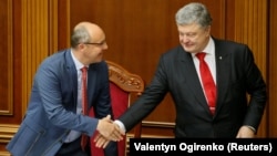Ukrainian President Petro Poroshenko (right) shakes hands with parliament speaker Andriy Parubiy after voting on a law to establish an anticorruption court during a parliament session in Kyiv on June 7.
