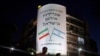 Israel -- People walk past a large billboard depicting both national flags of Israel (R) and Iran reading 'The Iranian embassy in Israel will open soon' in central Tel Aviv, August 27, 2015