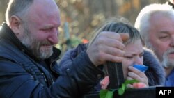 Të afërmit e një udhëtareje që ka humbur jetën në aeroplanin rus qajnë para varrit të saj