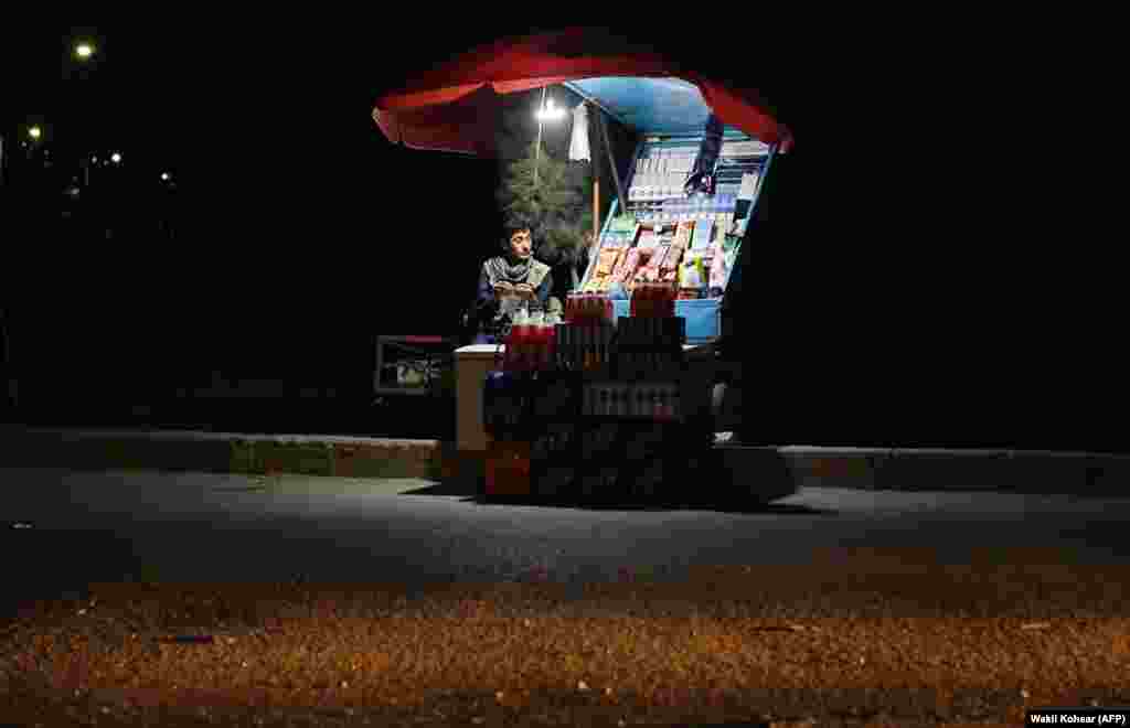 An Afghan cigarette vendor waits for customers at his stall along a road in Kabul. (AFP/Wakil Kohsar)