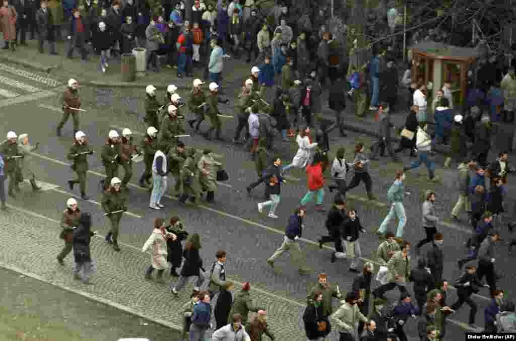 Riot police officers chase protesters on January 15, 1989. Batons, dogs, and water cannon were all employed to break up the demonstrations.&nbsp;