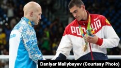 Russian boxer Yevgeny Tishchenko (right) shakes hands with Kazakhstan's Vasly Levit after their controversial heavyweight bout at the Rio Olympics. 