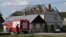 A Polish police officer attends the scene as firefighters work on the destroyed roof of a house on September 10 after Russian drones violated Polish airspace during an attack on Ukraine. Some of the drones were shot down by Poland with backing from its NATO allies. 