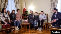 Qatar's ambassador to Russia, Sheikh Ahmed bin Nasser Al Thani (center) and Alexei Ghazaryan, head of the Russian Office of the Commissioner for Children's Rights meet Ukrainian children and their family members before their departure to Ukraine at the Qatari Embassy in Moscow on December 5.