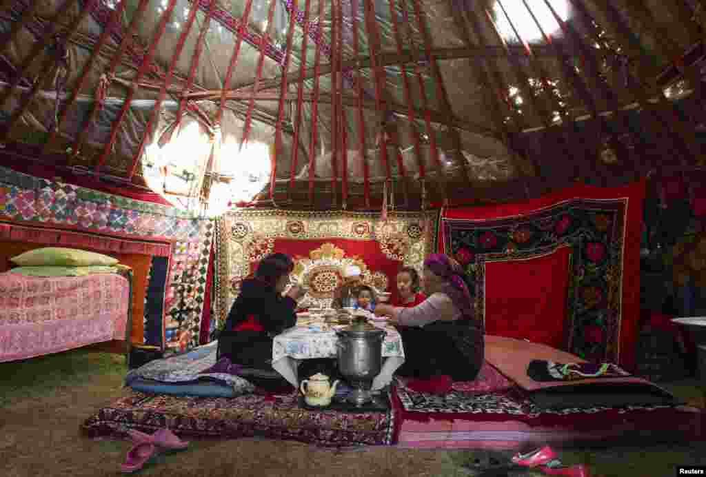 A family shares breakfast inside their yurt.