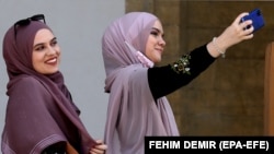 Djevojke s maramama prave selfie ispred Begove džamije u Sarajevu, 12. aprila 2021. 