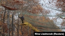 Ілюстраційне фото. Комунальний працівник чистить антидронові сітки від листя, Херсон, листопад 2025 року