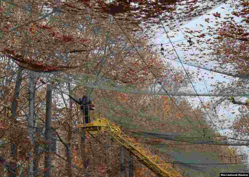 Një punëtor komunal pastron rrjetën antidronë të vendosur në Herson, qytet ukrainas në vijën e frontit. 11 nëntor 2025.