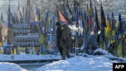 د کییف ښار په یوه څنډه کې يو اوکراینی وګړی له ملي سرتېري سره روان دي ـ انځور له ارشيفه