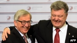 Ukrainian President Petro Poroshenko (right) is greeted by the president of the European Commission, Jean-Claude Juncker, in Riga.