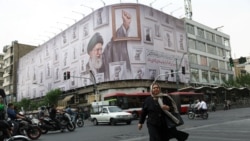 A woman walks near a billboard with an image of the late Iranian Supreme Leader Ayatollah Ali Khamenei in Tehran on May 19. 