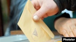 Armenia -- A voter casts a ballot in Yerevan.