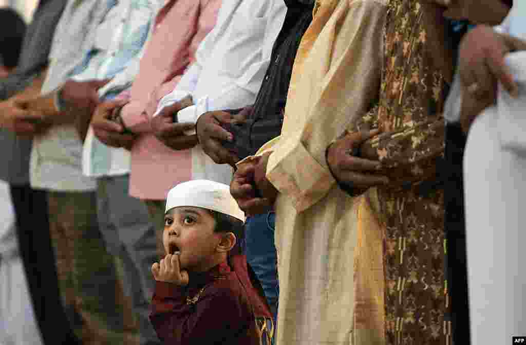 Мальчик смотрит на верующих в мечети Турки бин Абдуллах в Эр-Рияде, столице Саудовской Аравии.