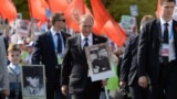 Володимир Путін (с) несе нібито портрет свого батька під час маршу «Безсмертний полк» 9 травня. Москва, Росія. 2015 рік