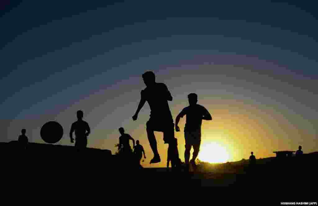 Afghan boys play soccer on a field in Herat. (AFP/Hoshang Hashimi)