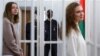 Katsyaryna Andreyeva (right) and Darya Chultsova stand inside the defendants' cage during the court hearing in Minsk on February 18.