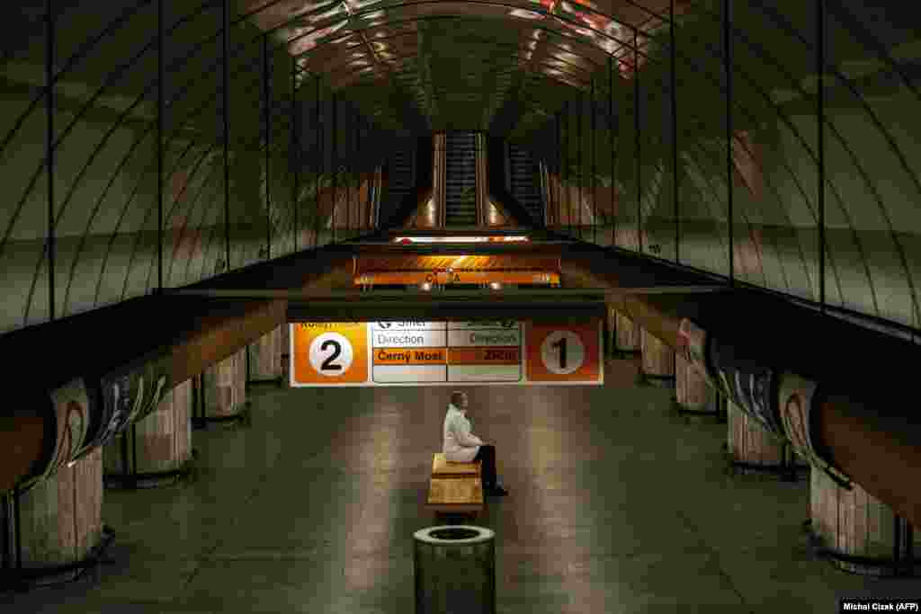 A woman sits on a bench in an empty subway station in Prague. (AFP/Michal Cizek)