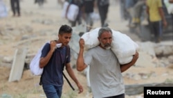 Palestinezët duke bartur ndihma të ofruara nga GHF-ja. 
