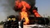Afghan firefighters attempt to extinguish a burning fuel tanker which was hit by a magnetic bomb on the outskirts of Jalalabad