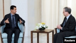 Syrian President Bashar al-Assad (left) meets with U.S. Ambassador Robert Ford in Damascus on January 27.