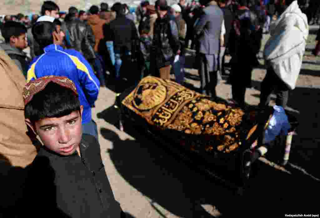 Afghans attend a funeral ceremony for a victim of twin bombings that targeted the parliament building in Kabul. A double suicide attack killed at least 38 people. (epa/Hedayatullah Amid)