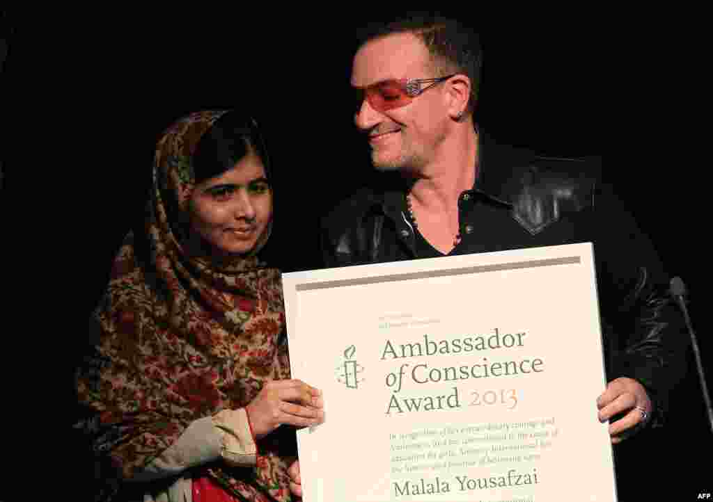 Yousafzai receives the Amnesty International Ambassador of Conscience Award for 2013 from U2 singer Bono in Dublin on September 17, 2013.