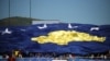 Երկրպագուները պահում են Կոսովոյի ֆուտբոլի ազգային հավաքականի հսկայական դրոշը, արխիվ
