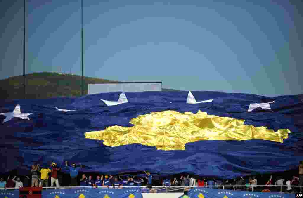 Supporters hold up a giant Kosovo national flag during a friendly soccer match between Kosovo and Turkey in the town of Mitrovica on May 21. (AFP/Armend Nimani)