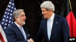 Presidential candidate Abdullah Abdullah (left) shakes hands with U.S. Secretary of State John Kerry in Kabul on July 11, 2014.