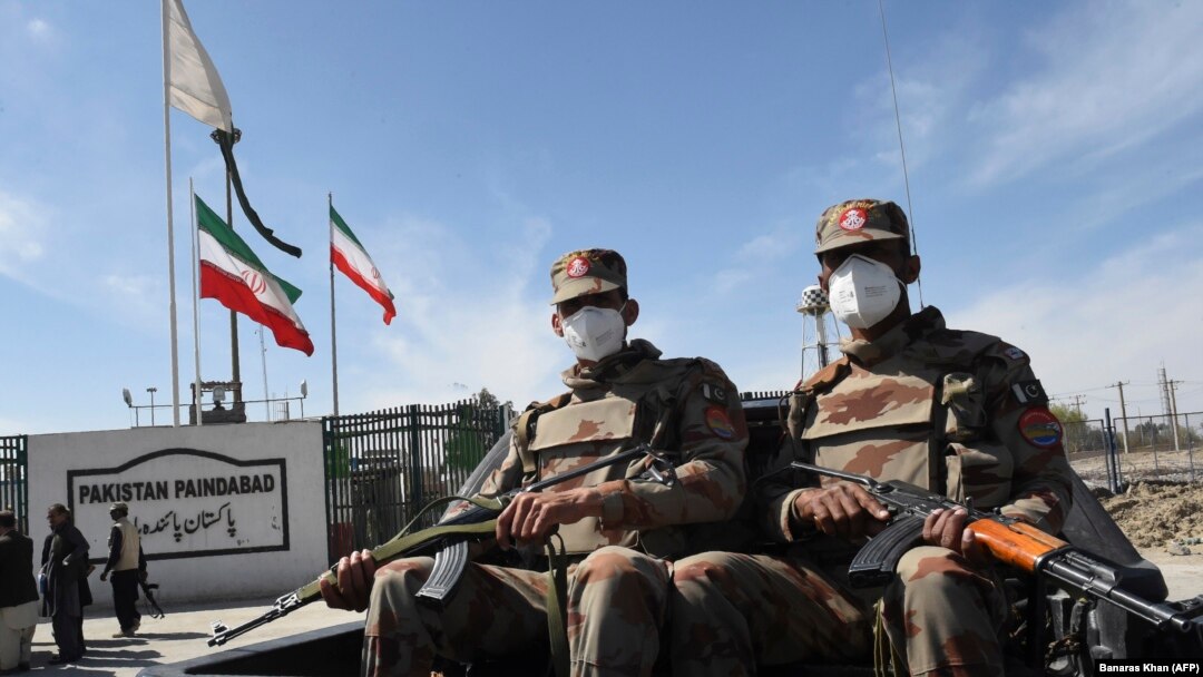 FILE: Pakistani soldiers wearing face masks patrol near the closed Pakistan-Iran border in Taftan in late February.