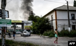 Зымыран түскен ауданда кетіп бара жатқан тұрғын. Донецк, 21 шілде 2014 жыл.