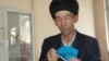 Тусип Айнагул, переселенец из Китая, показывает удостоверения оралмана с истекшим сроком действия. Алматы, 25 января 2019 года.