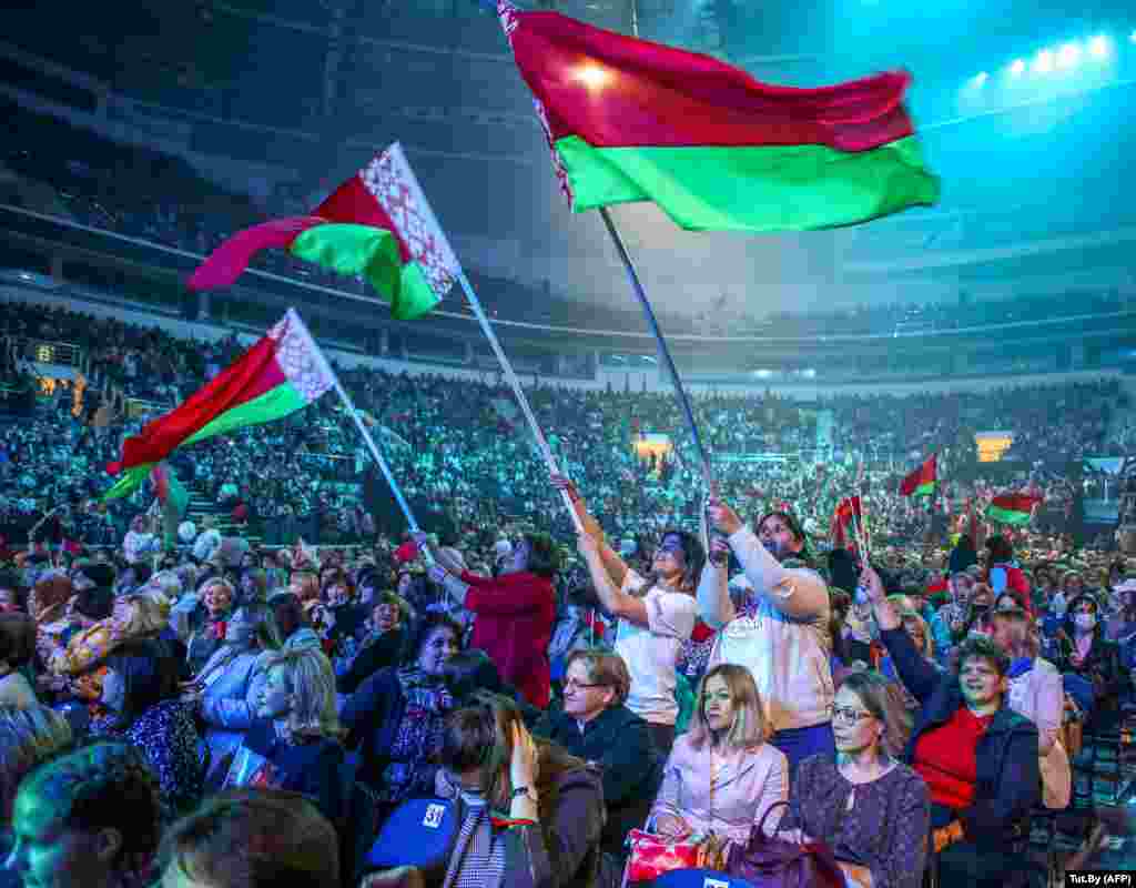 Supporters of embattled Belarusian President Alyaksandr Lukashenka wave Belarus national flags as they attend an event in Minsk on September 17. (AFP)