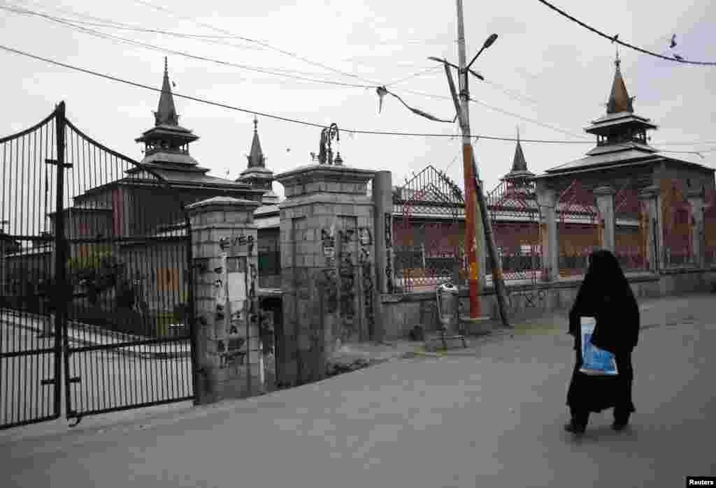 Një grua kalon pranë një xhamie në Kashmirin e banuar me shumicë myslimane.&nbsp;