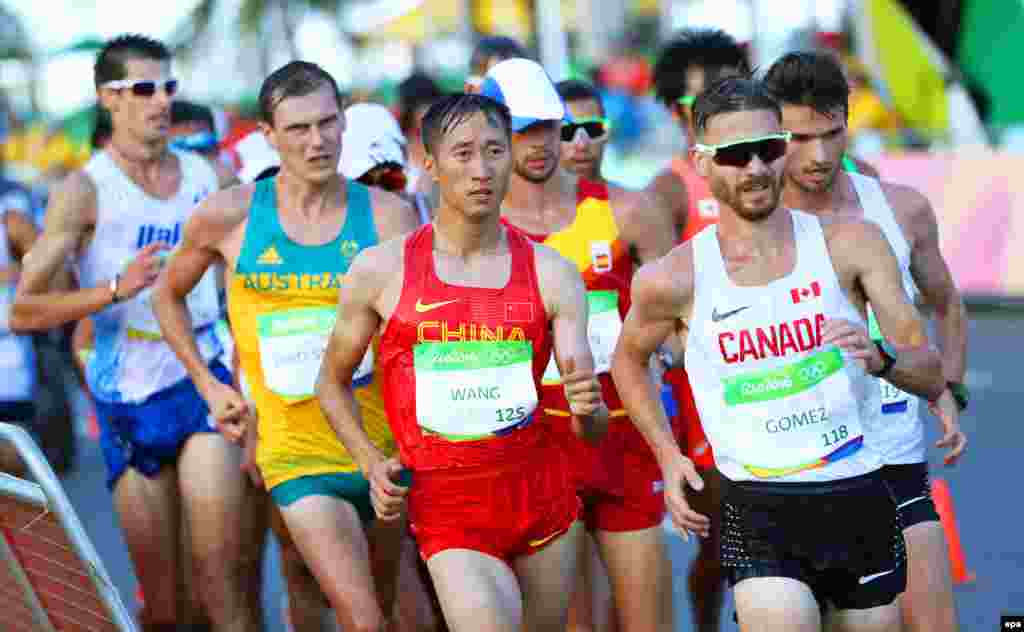 Wang Zhen (center) of China is on his way to win the gold medal in the men's 20-kilometer race walk.