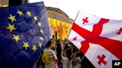Demonstrators gather with Georgian national and EU flags during a pro-EU and anti-government rally in front of the parliament in Tbilisi on July 3.