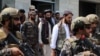 Anas Haqqani (center), the youngest son of Taliban co-founder Jalaluddin Haqqani, is escorted by Taliban fighters as he visits Hamid Karzai International Airport after the U.S. withdrawal in Kabul on August 31.