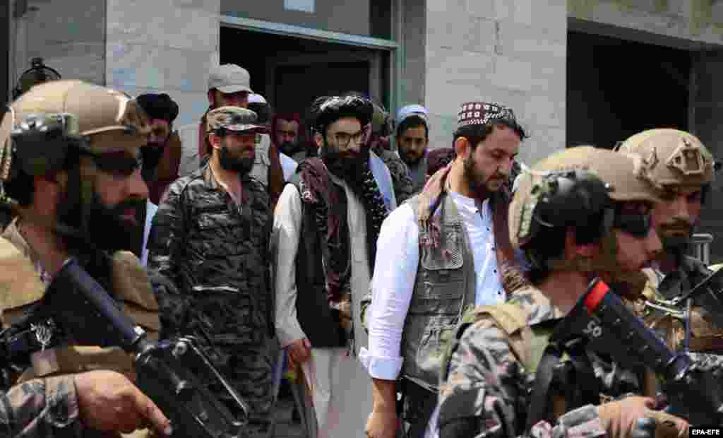 Anas Haqqani (C), fiul cel mic al cofondatorului talibanilor Jalaluddin Haqqani, este escortat de luptători talibani, în timpul vizitei la Aeroportul Internațional Hamid Karzai, după retragerea SUA, la Kabul, 31 august 2021.