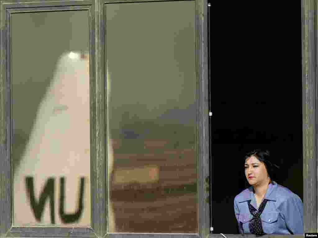 An Iraqi woman watches U.N. weapons inspectors leave Saddam airport in Baghdad March 18, 2003. Weapons inspectors left Iraq by plane on Tuesday after the United Nations told them to cut short their hunt for hidden weapons of mass destruction ahead of a likely U.S.-led invasion. REUTERS/Goran Tomasevic