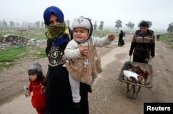 Displaced Iraqis from different areas in Mosul flee their homes after clashes broke out as Iraqi forces battle with Islamic State militants in the city on March 17.