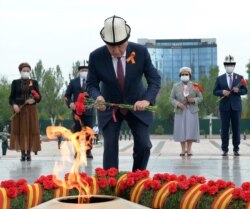 Қырғызстан президенті Сооронбай Жээнбеков, бұрынғы президент Роза Отунбаева Мәңгілік алауға гүл қойып жатыр. Бішкек, 9 мамыр 2020 жыл.