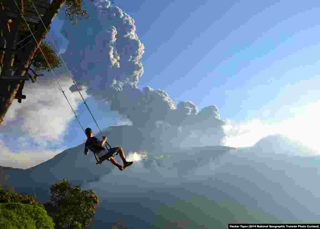 "End of the World" by Sean Hacker Teper. Banos, Ecuador. "This photo, taken at the 'end of the world' swing in Banos, Ecuador, captures a man on the swing overlooking an erupting Mt. Tungurahua. The eruption took place on February 1st, 2014. Minutes after the photo was taken, we had to evacuate the area because of an incoming ash cloud." 