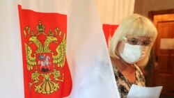 Женщина в маске на избирательном участке в Московской области. В России проходит голосование по поправкам к Конституции.