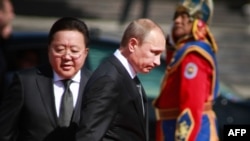 Russian President Vladimir Putin is escorted by Mongolian President Tsakhiagiin Elbegdorj (left) during a welcoming ceremony in Ulan Bator.