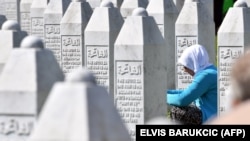 A woman prays near the graves of victims of the Srebrenica massacre in Bosnia-Herzegovina. (file photo)