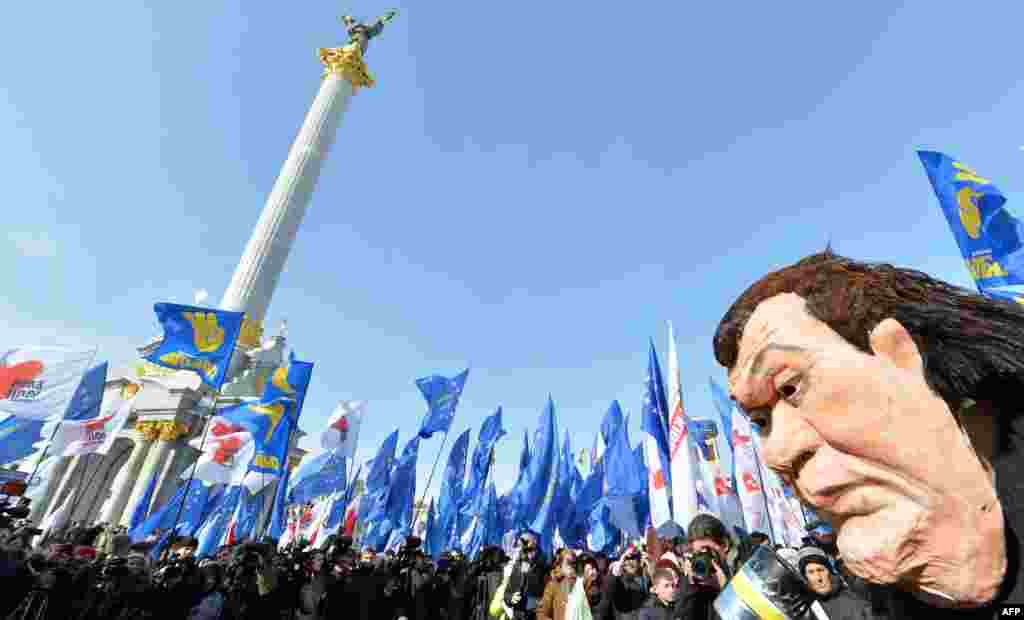 A Ukrainian opposition activist wearing a mask depicting President Viktor Yanukovych attends a mass rally &quot;against political repression!&quot; on Independence Square in Kyiv. (AFP/Sergei Supinsky)