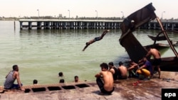 Iraqis swim near Basra in an effort to beat the searing summer heat on August 3. 