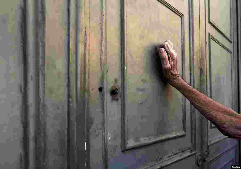 A pensioner leans against the main door of a branch of the National Bank in Athens amid Greece's battles with the European Union over its debt crisis. (Reuters/Yannis Behrakis)